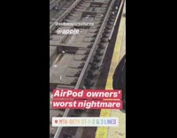 Worker trying to pick up white headphones from train track with claw 