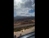 Man Drives Car on Long Mountaintop Road