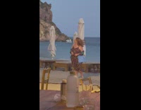 Woman printed black dress beach bar umbrellas