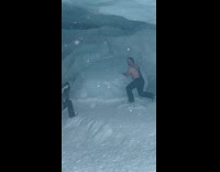 Friend throw snow on shirtless man in cave part 1