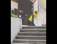 Yellow raincoat girl hugs blue metal pole  