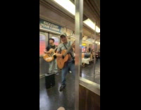Three men performs with guitars inside train