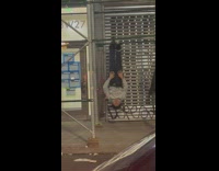 Man hanging upside down on scaffolding bar 