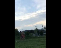 Blonde lady in bikini poses in grass field 