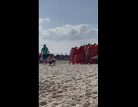Guy in white speedo poses with red chairs