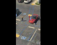 Lady Takes Picture with Guys Red Sports Car