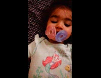 Girl with two pacifiers on her mouth