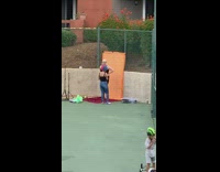 Lady in colorful wig takes photos for friend in black at park 