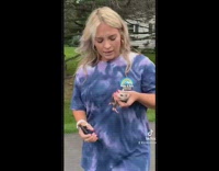 Girl picks up baby possum in middle of road 