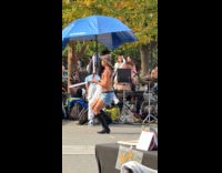 Man shirtless dances to performer at park