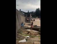 Kid takes picture mother pink bikini beach