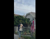 Guy walks on sidewalk with doll on backpack