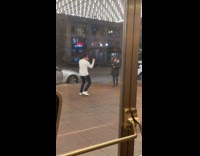 Man white sweatshirt music video on sidewalk