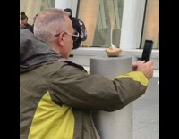 Man takes duck lips selfie with food on pillar pole