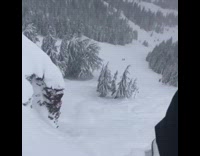 Guy skis off very tall cliff and falls down, ski goes flying down slope