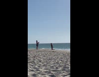 Woman black swimsuit kneel and act beach