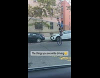 Man blue tank top use tall unicycle