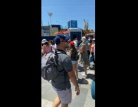 Long line to take picture in front of large yellow sign