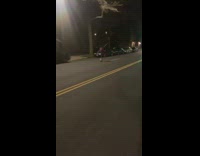 Red sweater person dances street with sticks 