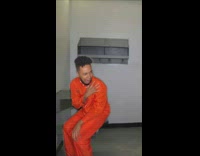 Guy wearing orange jumpsuit cries in jail 