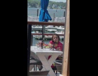 Woman pink shirt dine outside docks tripod