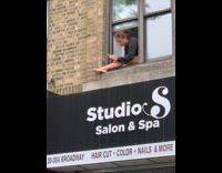 Woman shave her legs outside the window of the apartment 