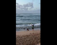 Woman bikini with hat kneels at beach