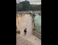 Two girls dance beside stairs water fountain