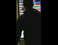 woman rubs white phone along a screen in subway staion