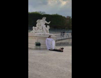 Woman in white dress poses in front of the statue
