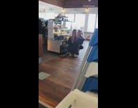 Two woman pose beside cake store display