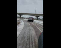 Large red truck drifting on snow and ice covered road