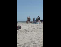 Couple on beach flex back and biceps