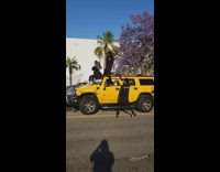 Two people car roof music video shoot protest