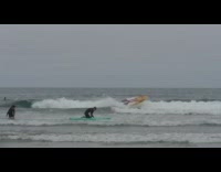 Shirtless surfer runs into black wetsuit surfer