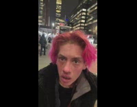 Woman pink hair walks up to guy recording video new york