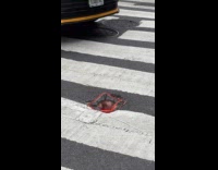 Traffic cone jammed on hole on crosswalk