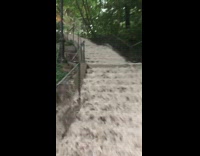 Staircase looks like a waterfall after rain floods streets