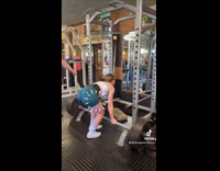 Woman drops squat bar weight on leg