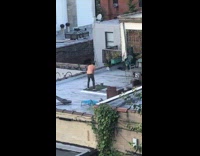 Shirtless man plays mini golf on rooftop 