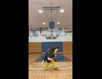 Harlem globetrotters mascot shoots basketball backwards 