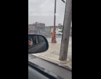 Wooden pole on sidewalk taped together with some orange tape