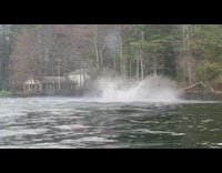 Guy wearing wetsuit does flips on jet ski 