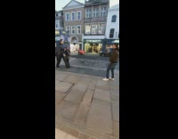 Woman takes picture with big woman statue