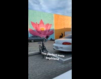 Guy takes picture in front of large flower picture