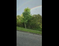 Person in moving car film double rainbow