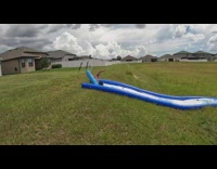 Slow motion of kid on slip and slide that scorpions after failing
