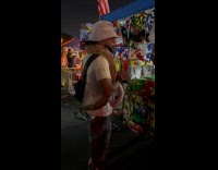 Man with snake on shoulder near store