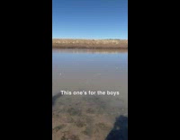 Guy throws ice on frozen lake 