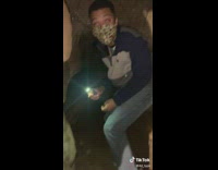 Guy and his friends exploring cave camera makes his eyes red